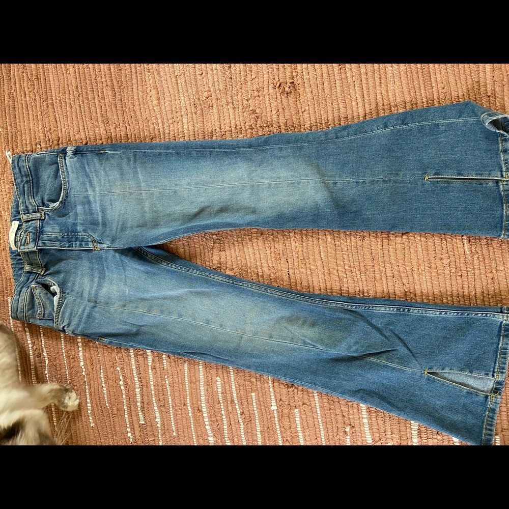 Flared denim jeans with cutouts at the bottom